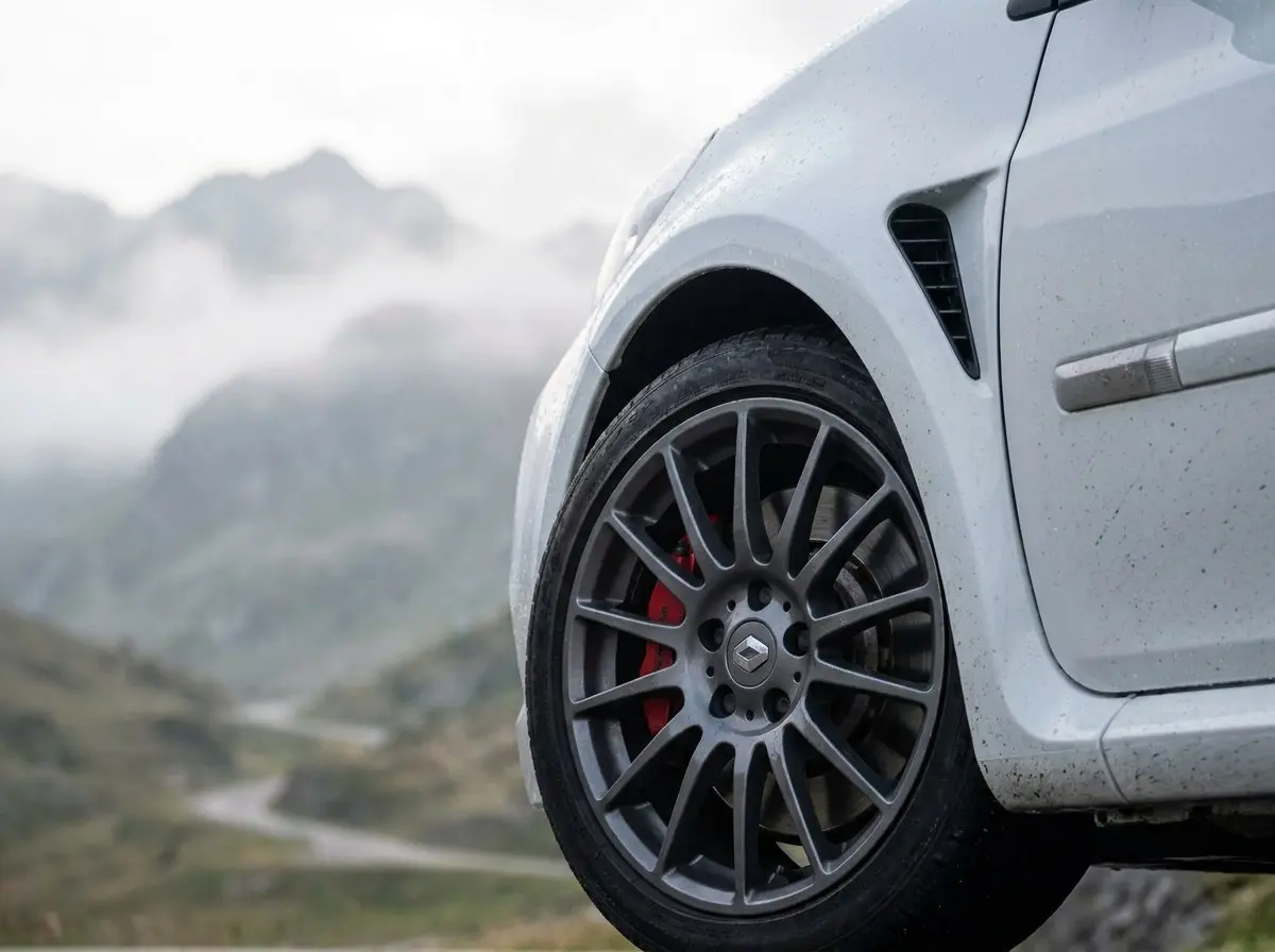 Détail Clio 3 RS : aile avant élargie et jante anthracite avec étrier rouge
