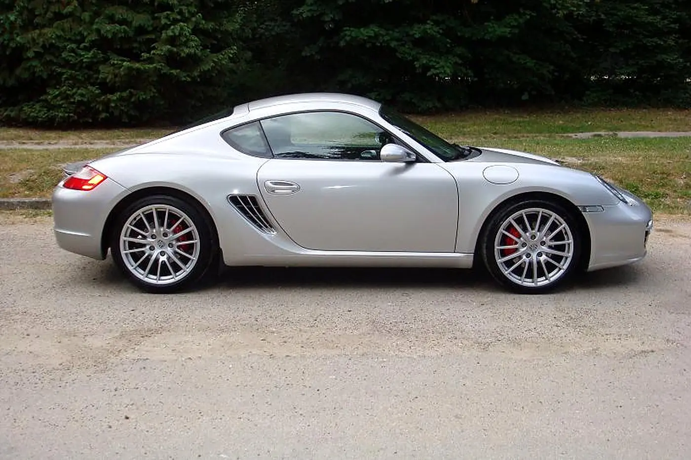 Porsche Cayman S 987 gris argent de profil, étriers rouges et prise d'air latérale